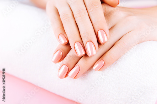 Beautiful Woman Hands on towel. Spa and Manicure concept. Female hands with pink manicure. Soft skin, skincare concept. Beauty nails. over beige background.