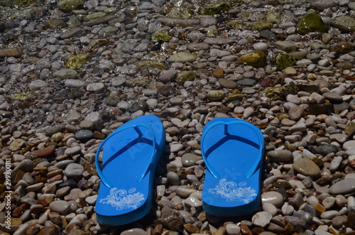 Niebieskie klapki na kamienistej plaży