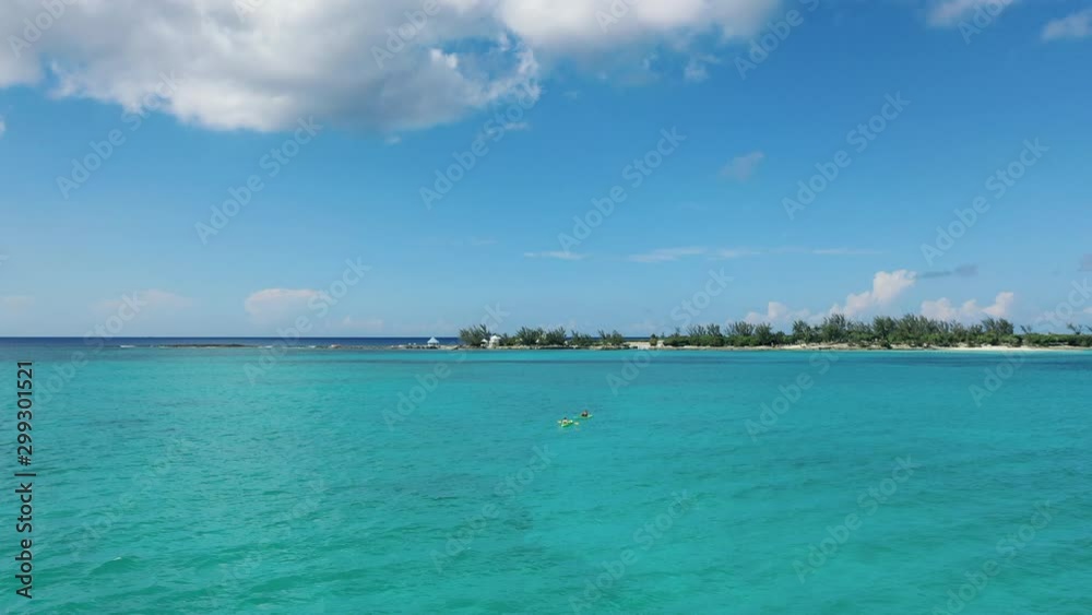 Aerial: Two Men Kayaking in Crystal Clear Blue Water - Nassau, Bahamas Aerial: Two Men Kayaking in Crystal Clear Blue Water - Nassau, Bahamas