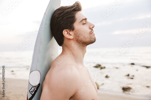 Surfer with surfing on a beach outside.