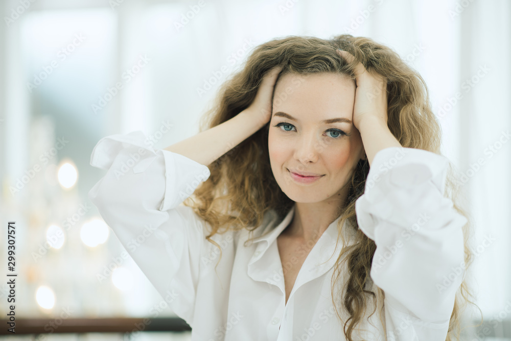 Young beautiful girl with white shirt on the bed. Lifestyle young women curly hair attractive awake relaxing on morning. Young beautiful girl with white shirt on the bed. Lifestyle young women curly hair attractive awake relaxing on morning.