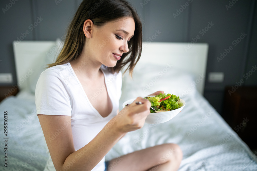 Portrait of a lovely pretty girl eating fresh salad from a bowl Portrait of a lovely pretty girl eating fresh salad from a bowl