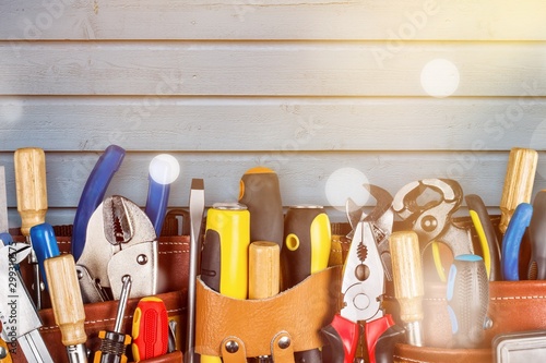 Tool belt with tools on wooden background