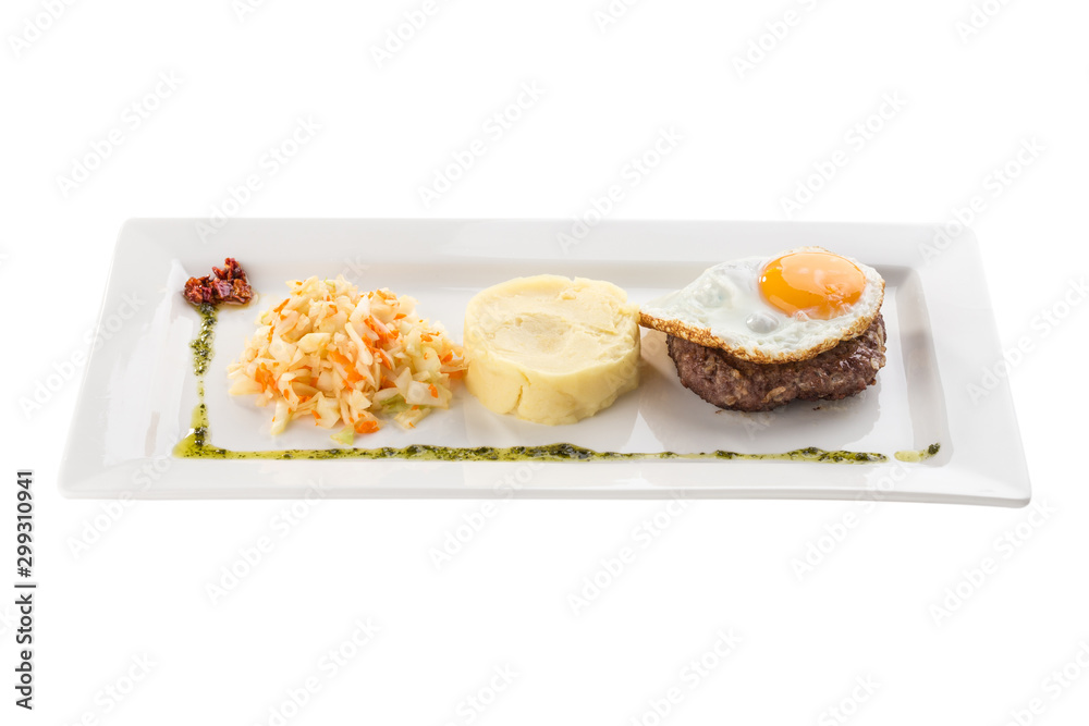 Fried egg with beefsteak, mashed potatoes and pickled cabbage on white plate isolated on white background