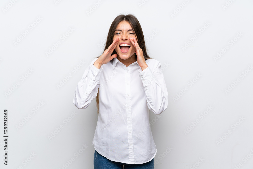 Young woman over isolated white background shouting with mouth wide open Young woman over isolated white background shouting with mouth wide open