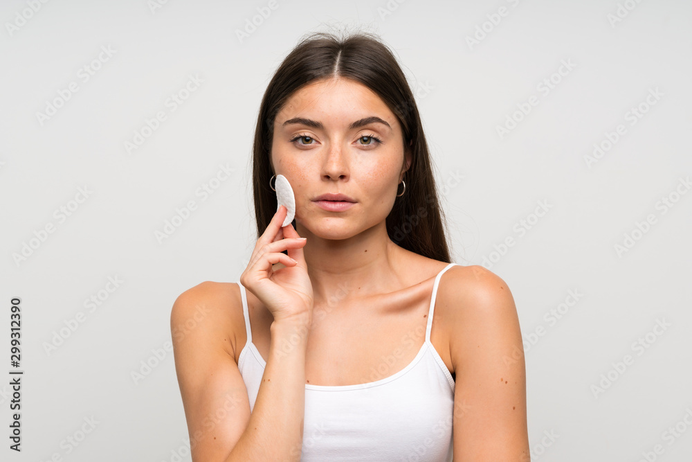 Pretty young woman removing makeup from her face with cotton pad Pretty young woman removing makeup from her face with cotton pad