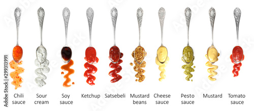 Photography Set of spoons with different delicious sauces on white background, top view