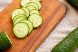 Ripe mini baby cucumbers on a rustic wooden board, low angle view. Close-up.