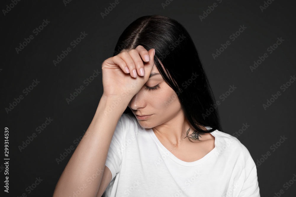 Portrait of upset young woman on dark background Portrait of upset young woman on dark background