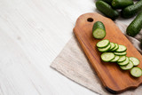 Fresh mini baby cucumbers on a rustic wooden board, low angle view. Copy space.