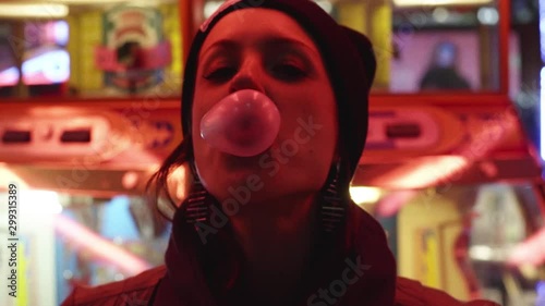 primo piano di ragazza che fa un palloncino con la gomma da masticare al luna park photo