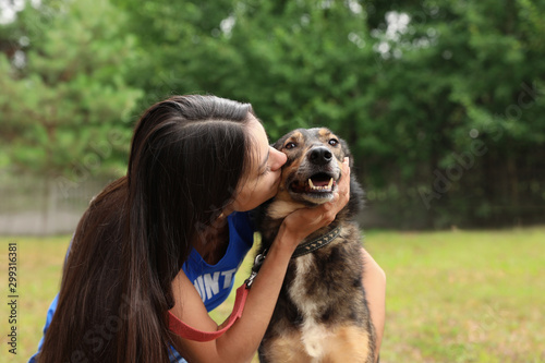 Female volunteer with homeless dog at animal shelter outdoors