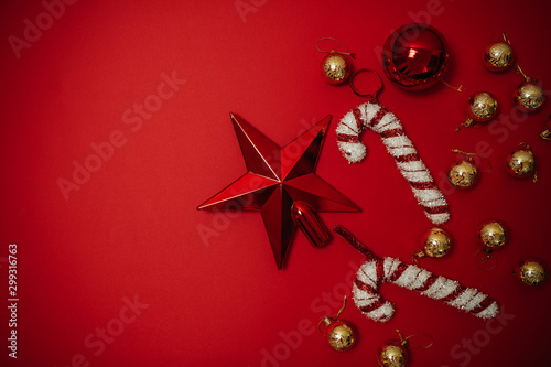 Christmas ornaments on the red background. Christmas decorations with space for text. Candy canes and christmas balls isolated. Greeting card.