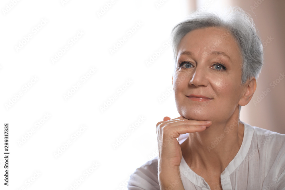 Happy mature woman near window indoors, space for text. Smart aging Happy mature woman near window indoors, space for text. Smart aging