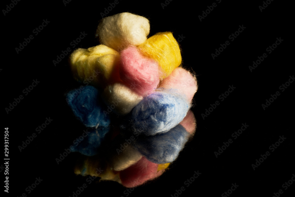 Bolas de algodon de colores sobre fondo negro Stock Photo | Adobe Stock