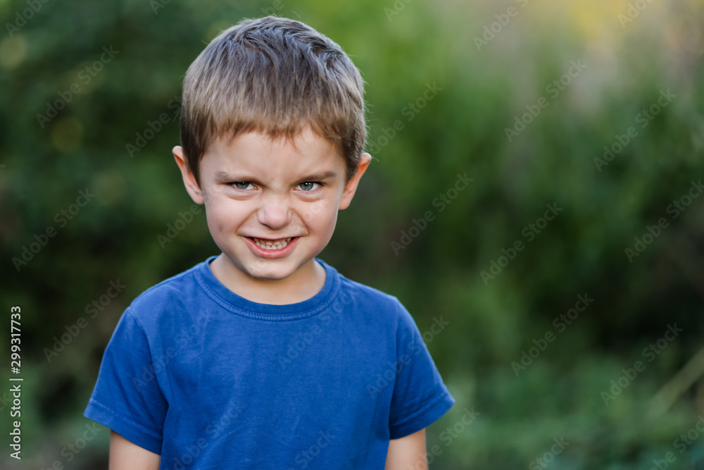 Portrait of a little boy of five years. The cunning, harsh, emotional angry face of a bully child. Portrait of a little boy of five years. The cunning, harsh, emotional angry face of a bully child.