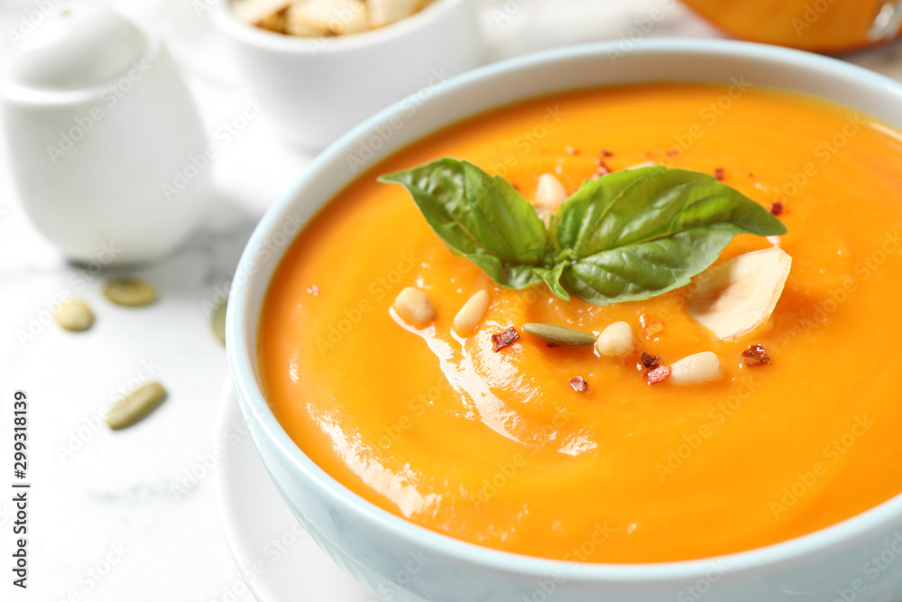 Delicious pumpkin soup in bowl on table, closeup Delicious pumpkin soup in bowl on table, closeup