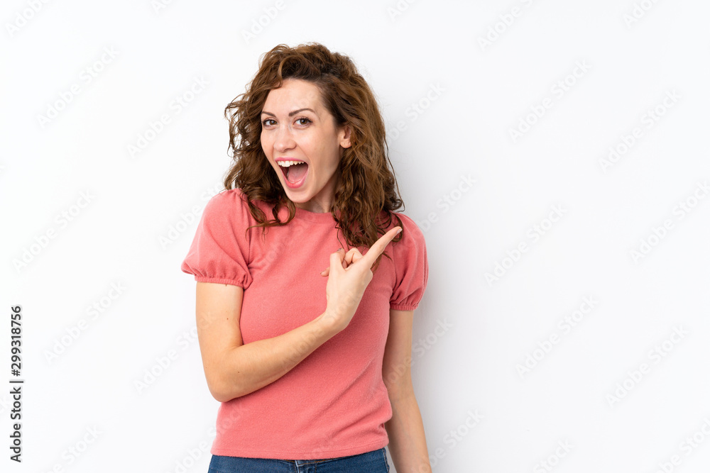 Young pretty woman over isolated background surprised and pointing side Young pretty woman over isolated background surprised and pointing side