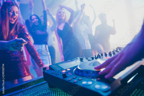 Dj playing stereo loud sound rhythm set for attractive stylish cheerful positive people crowd hang out enjoying evening having fun time festive concert at fashionable modern nightclub photo