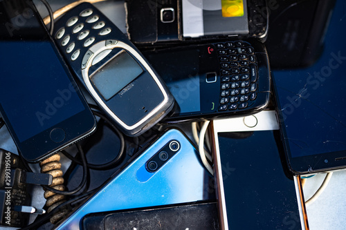 Close up on pile of  broken cell phones in an electonic waste collection centre photo