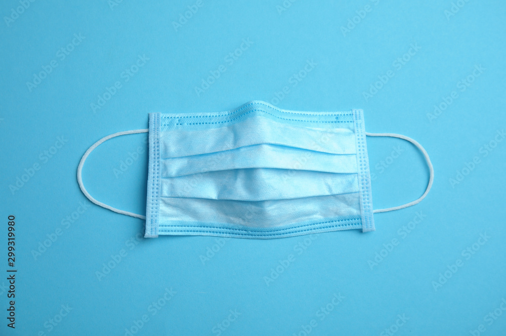 Medical face mask on blue background, top view Medical face mask on blue background, top view