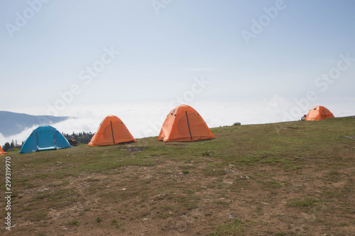 tents in the mountains. Orange camping tent in a morning light