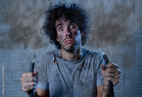 Canvastavla Funny image of man holding electrical cable after getting electric shock