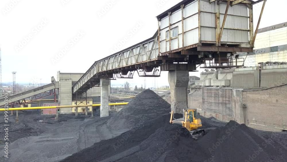 Bulldozer tractor collecting black coal on supply field of thermoelectric power station. Bulldozer tractor collecting black coal on supply field of thermoelectric power station.