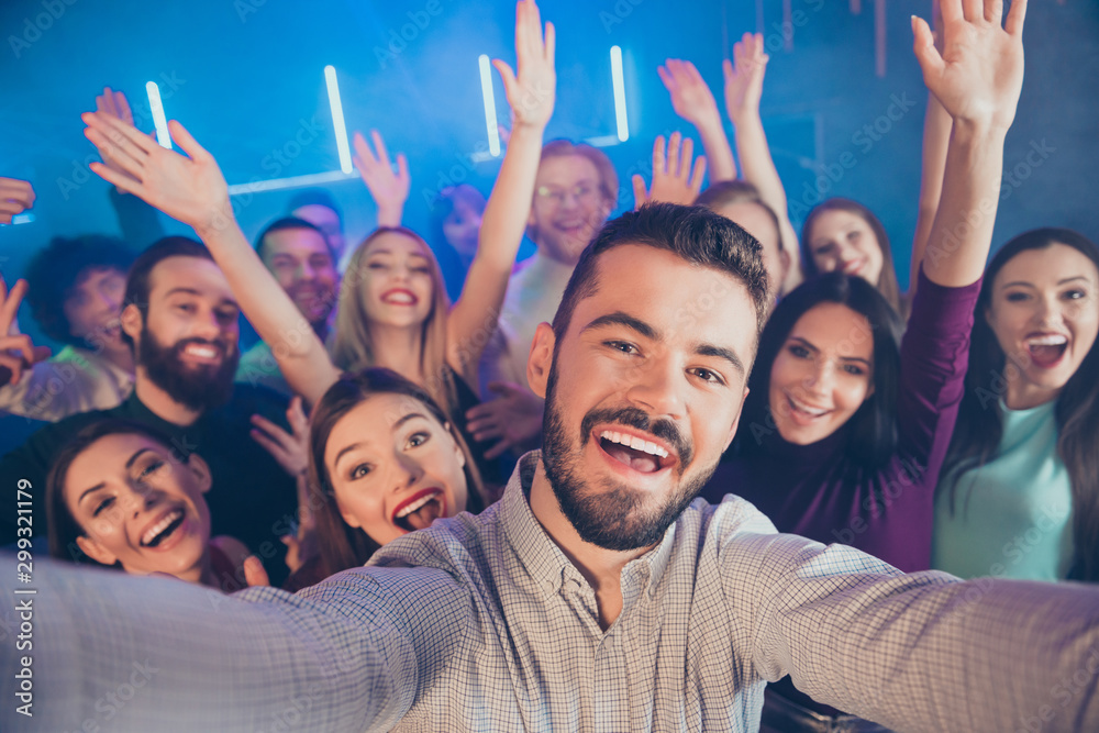 Close-up photo portrait of large crowd cheerful wit toothy beaming smile bearded youth youngster in fog smoke neon lights celebrating birthday taking selfie Close-up photo portrait of large crowd cheerful wit toothy beaming smile bearded youth youngster in fog smoke neon lights celebrating birthday taking selfie
