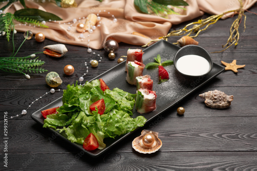 shrimp and strawberry rolls on a plate and cream in a cup