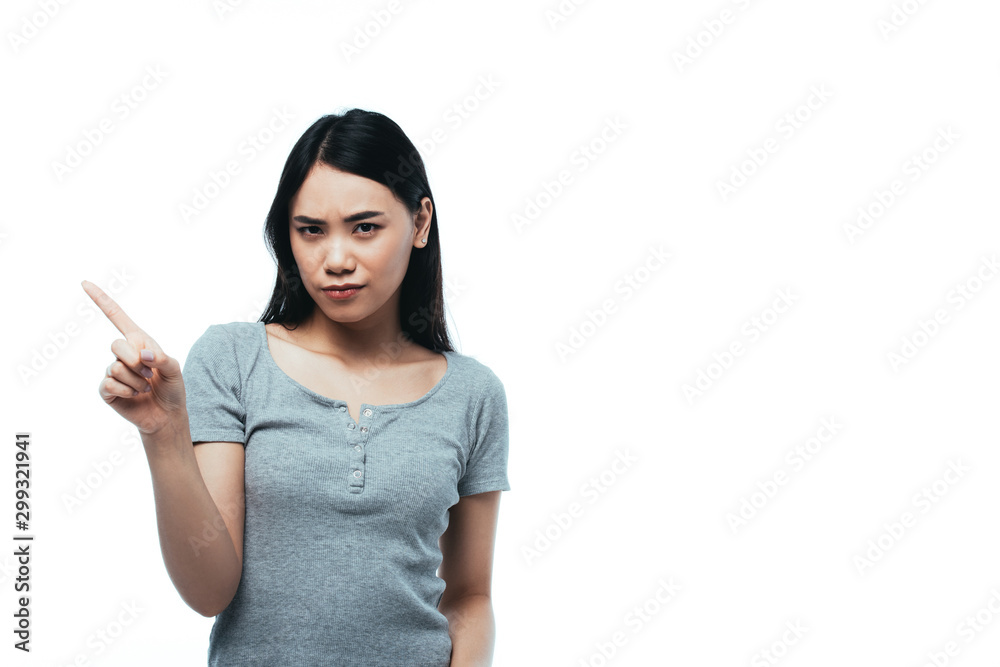 upset attractive asian girl pointing with finger isolated on white upset attractive asian girl pointing with finger isolated on white
