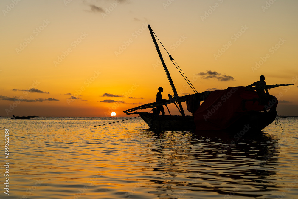 Traditional fisherman dhow boat during sunset on Indian ocean in island Zanzibar, Tanzania, East Africa