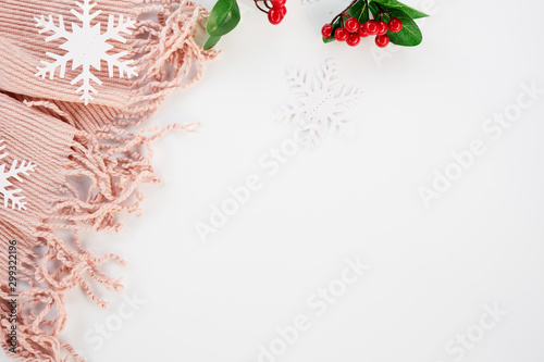 Christmas decorations, red berries, pink scarf on white background. Christmas, new year, winter concept. Flat lay, top view, copy space.
