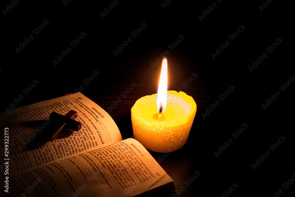 Burning candle and Bible . The psalms . Holy book . Christian cross