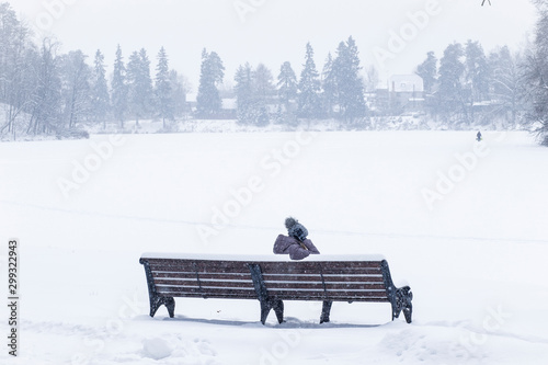Girl sitting on a bench in the Park in winter