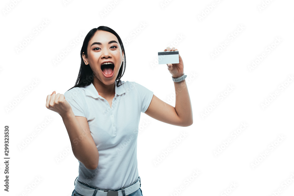 excited attractive asian girl holding credit card and laptop isolated on white excited attractive asian girl holding credit card and laptop isolated on white