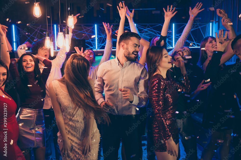 Photo of cheerful attractive beautiful students dressed in formalwear celebrating brithday of his friend surrounded by girls feeling carefree washed with neon light turned by dj