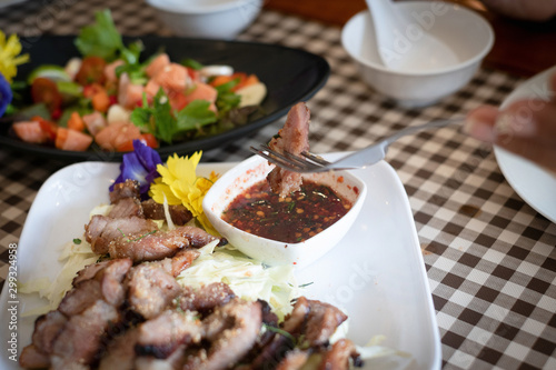 tasty slice grilled pork on tartan table,thai food with Thai chili sauce.