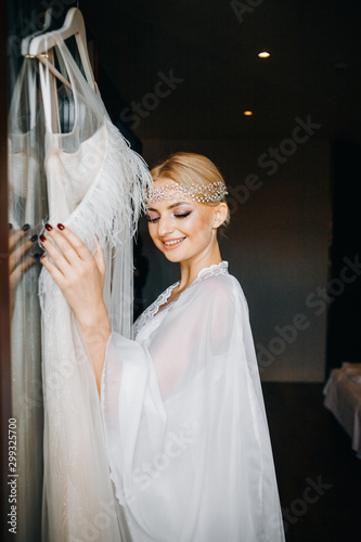 Mysterious bride stands near her wedding dress photo