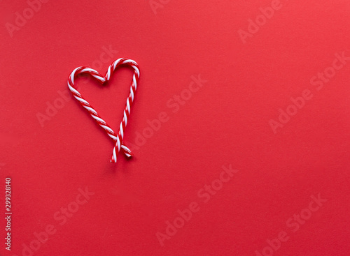 Christmas background heart of candy canes  on red background