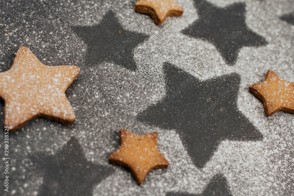 gingerbread cookies sprinkled with icing sugar on a dark gray background with space for text. Christmas baking. gingerbread cookies sprinkled with icing sugar on a dark gray background with space for text. Christmas baking.