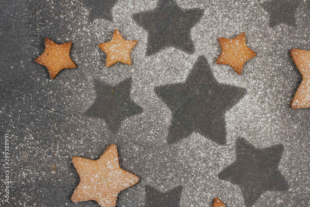 gingerbread cookies sprinkled with icing sugar on a dark gray background with space for text. Christmas baking. gingerbread cookies sprinkled with icing sugar on a dark gray background with space for text. Christmas baking.