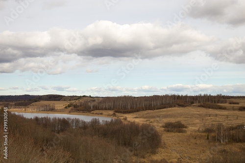 Panorama of the spring landscape with a lake and hills with copses. Izborsk  Pskov region  Russia.