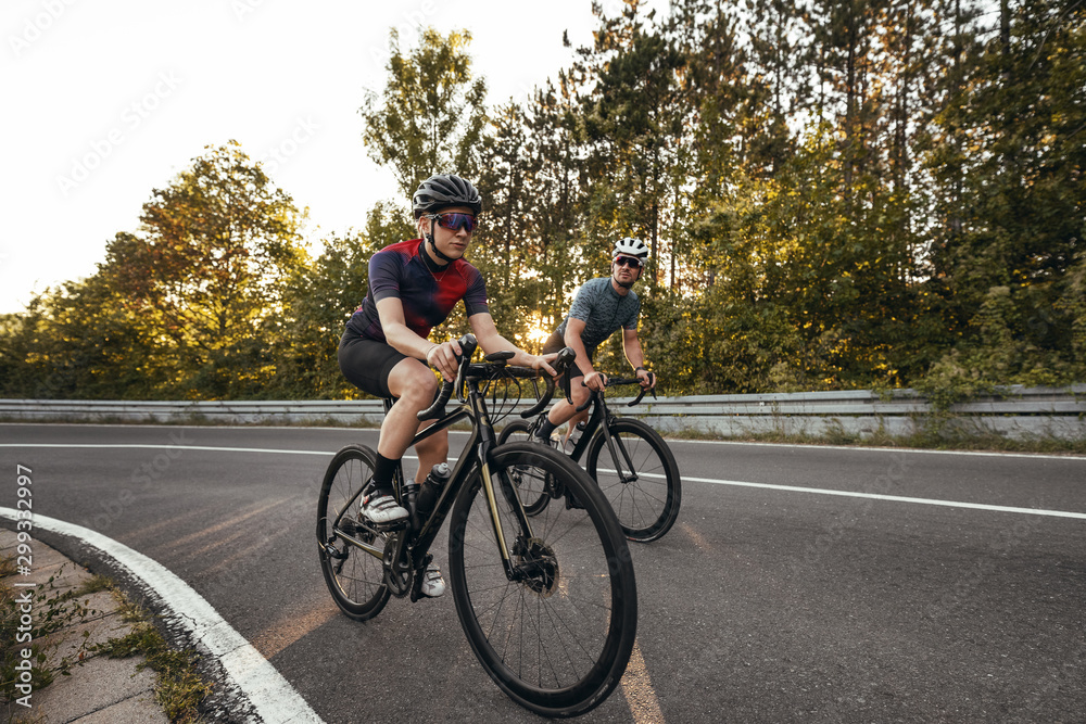 cyclists on a windy mountainroad in upper franconia at sunset cyclists on a windy mountainroad in upper franconia at sunset