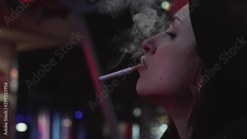 primo piano di ragazza di profilo che fuma una sigaretta al luna park photo