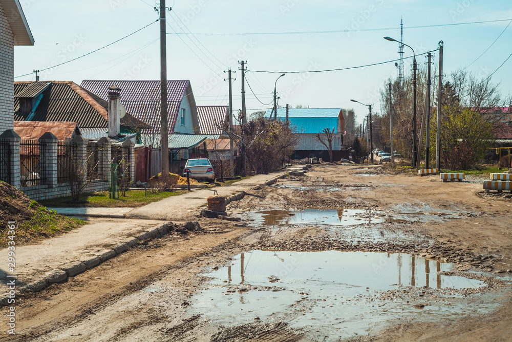 Dirty broken street in the old poor part of Yoshkao-Ola city, Russia