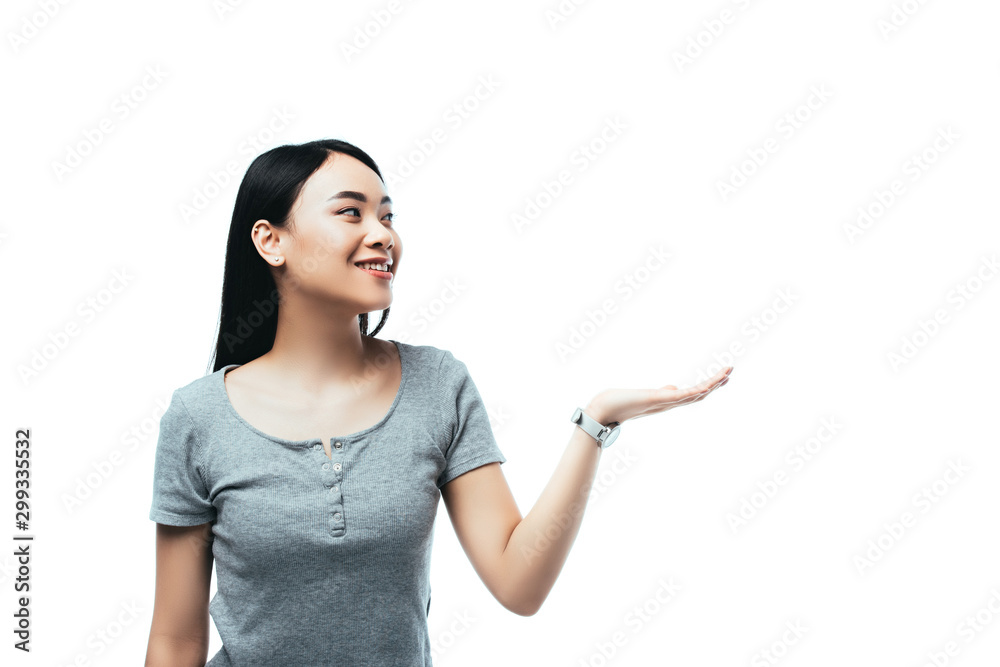 smiling asian girl pointing with hand away isolated on white smiling asian girl pointing with hand away isolated on white