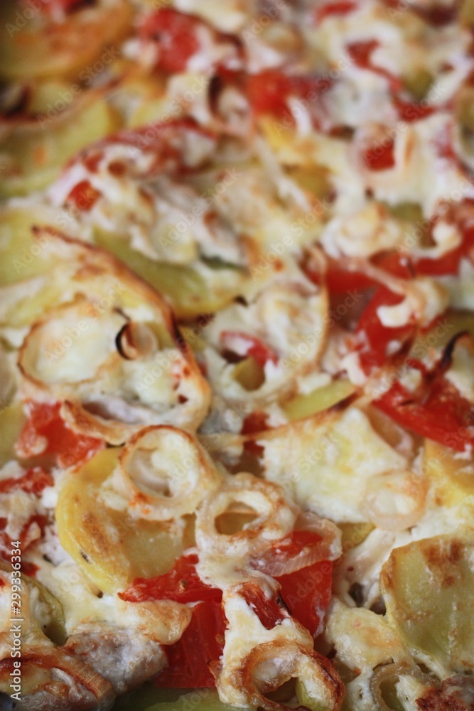 Baked potatoes with chicken and tomatoes close up
