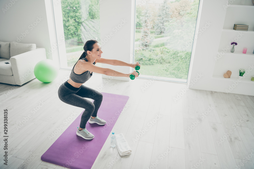 Obraz premium Top above high angle photo of active athlete girl stand profile side practice sport gymnastics make squats hold green dumbbells wear modern sporty pants in fitness studio