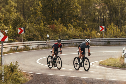 cyclists on a windy mountainroad in upper franconia at sunset photo